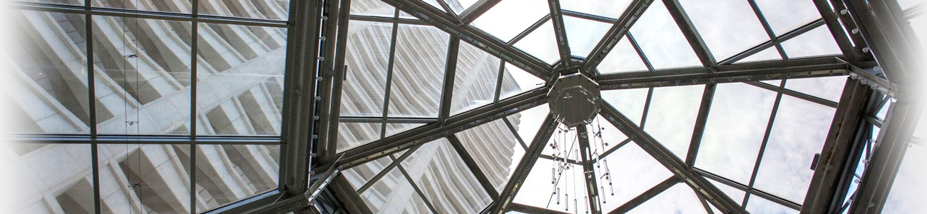 A transparent glass dome revealing a bright sky filled with fluffy white clouds